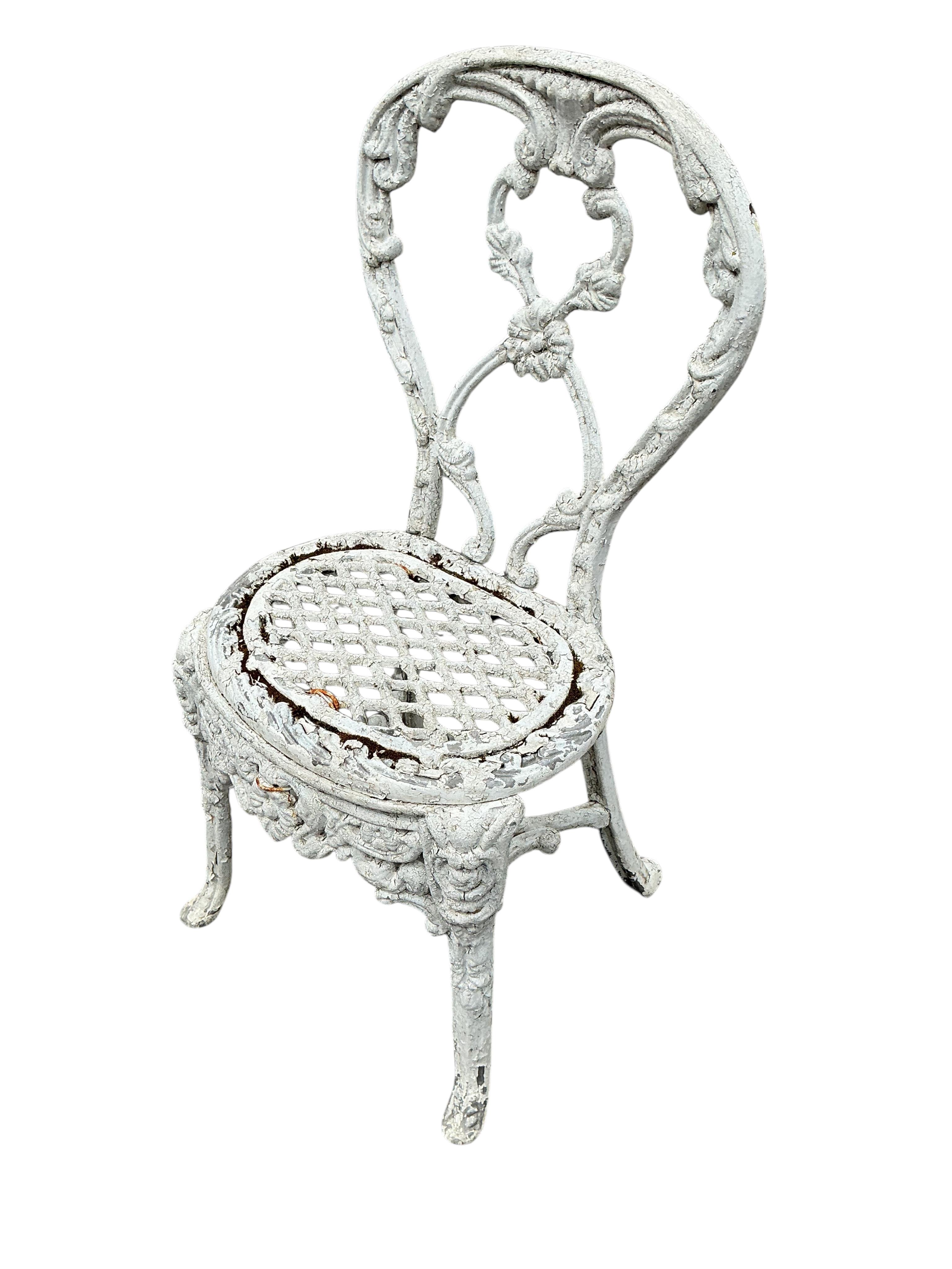 A Victorian Coalbrookdale style later painted circular cast iron garden table, diameter 61cm, height 70cm together with two later chairs
